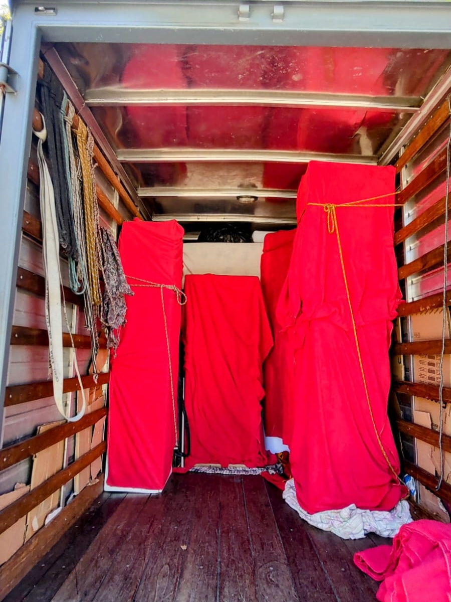 imagem do interior de um caminhão baú com moveis cobertos por mantas protetoras